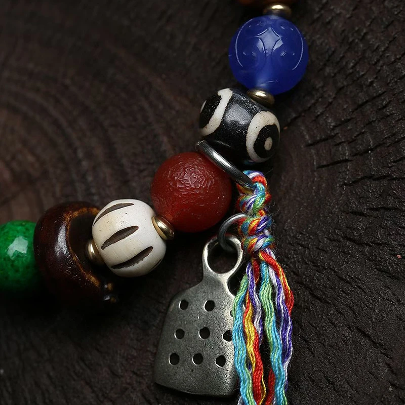 Multi-bead bracelet with single loop, featuring Nangla Tsatsa turquoise, agate, recycled bone, and 999 silver tassel accessories