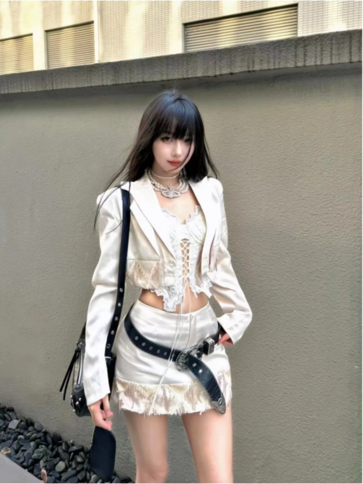 

Весенний комплект из трех предметов: глянцевый атласный жакет с бахромой, кружевная внутренняя отделка, юбка с высокой талией. Женская мода.