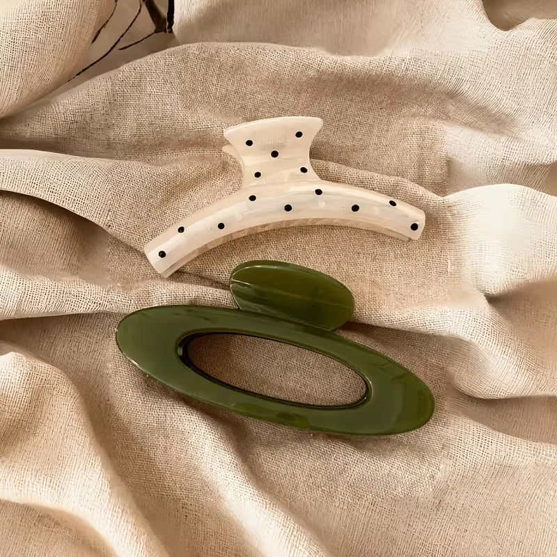 Large, lightweight plastic claw clip for women; oval design featuring a green-and-white polka-dot pattern; stylish, versatile, e
