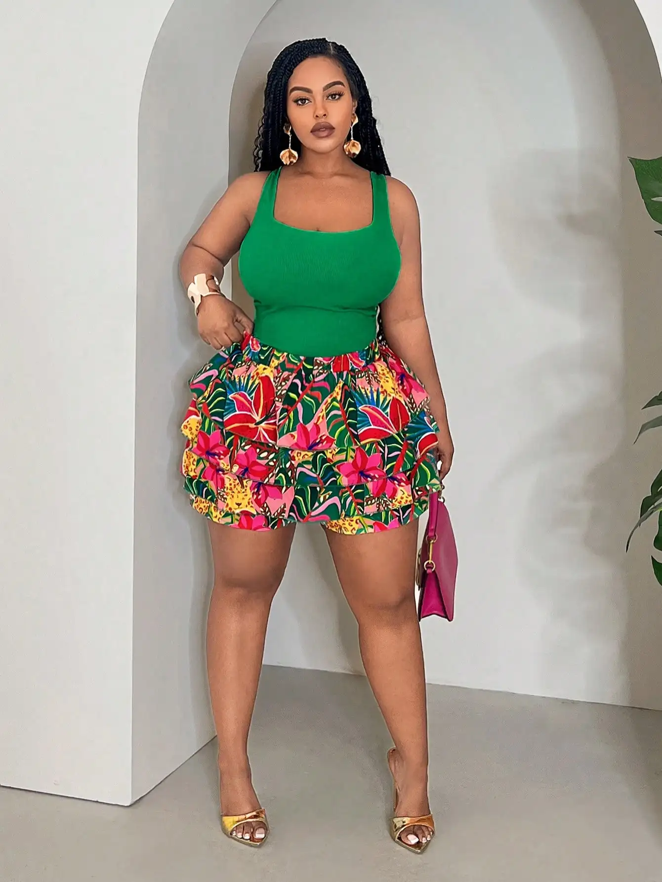 

Комплект из двух предметов для женщин больших размеров: укороченный топ-майка однотонного зеленого цвета и шорты с рюшами и тропическим принтом.