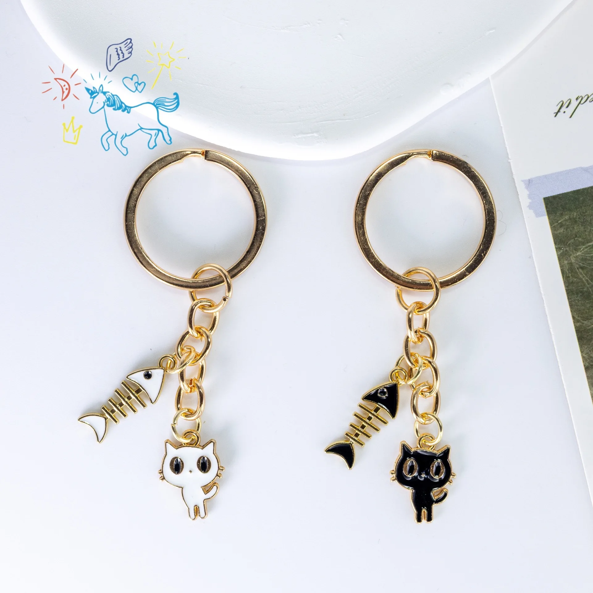 Moda blanco y negro gato hueso de pescado lindo goteo aleación colgante llaveros funda para auriculares bolsa colgante llaveros de coche Accesorios