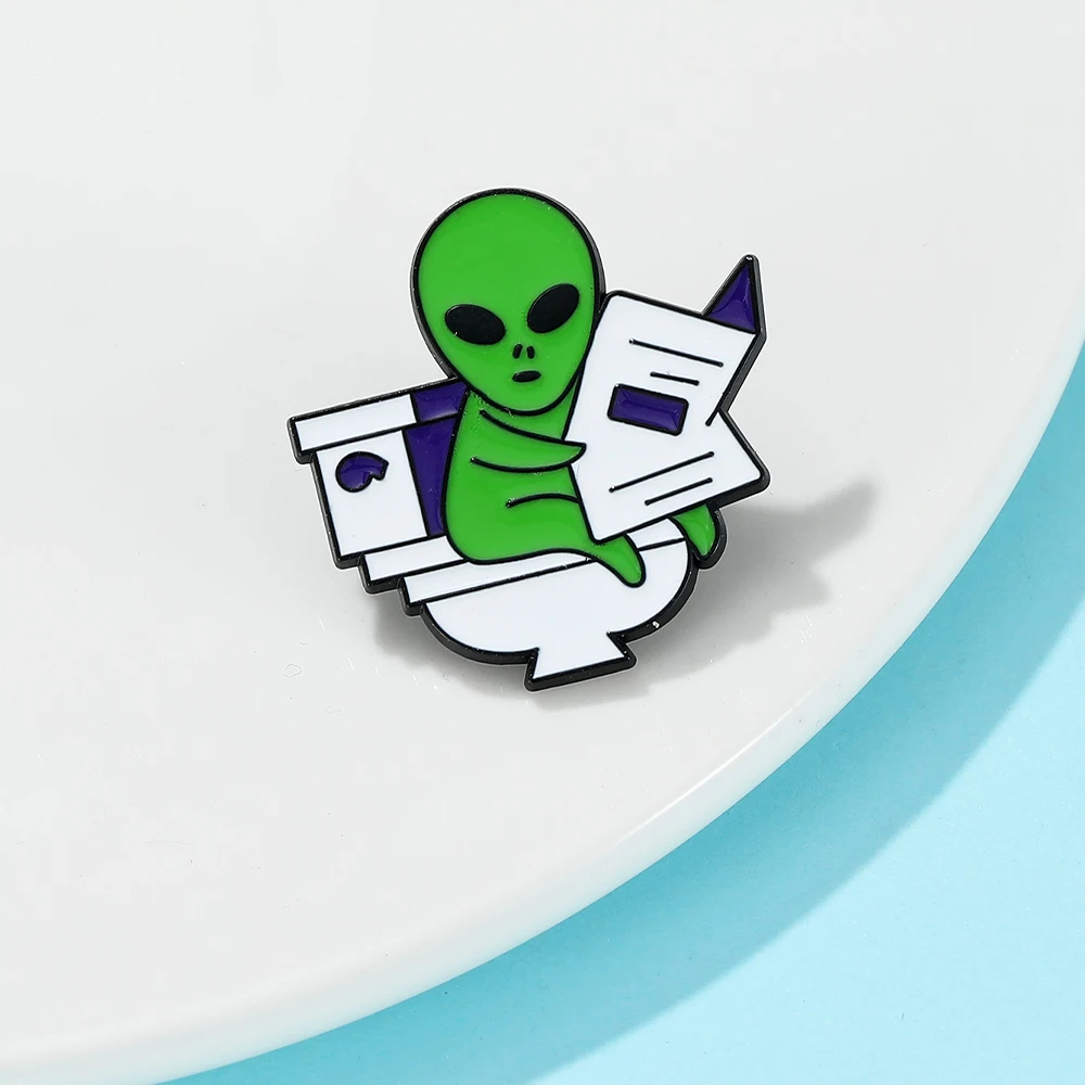 Funny Green Alien Enamel Pins Alien Sitting on Toilet Reading Newspaper Brooch, Zinc Alloy Humorous Sci-Fi Themed Badge