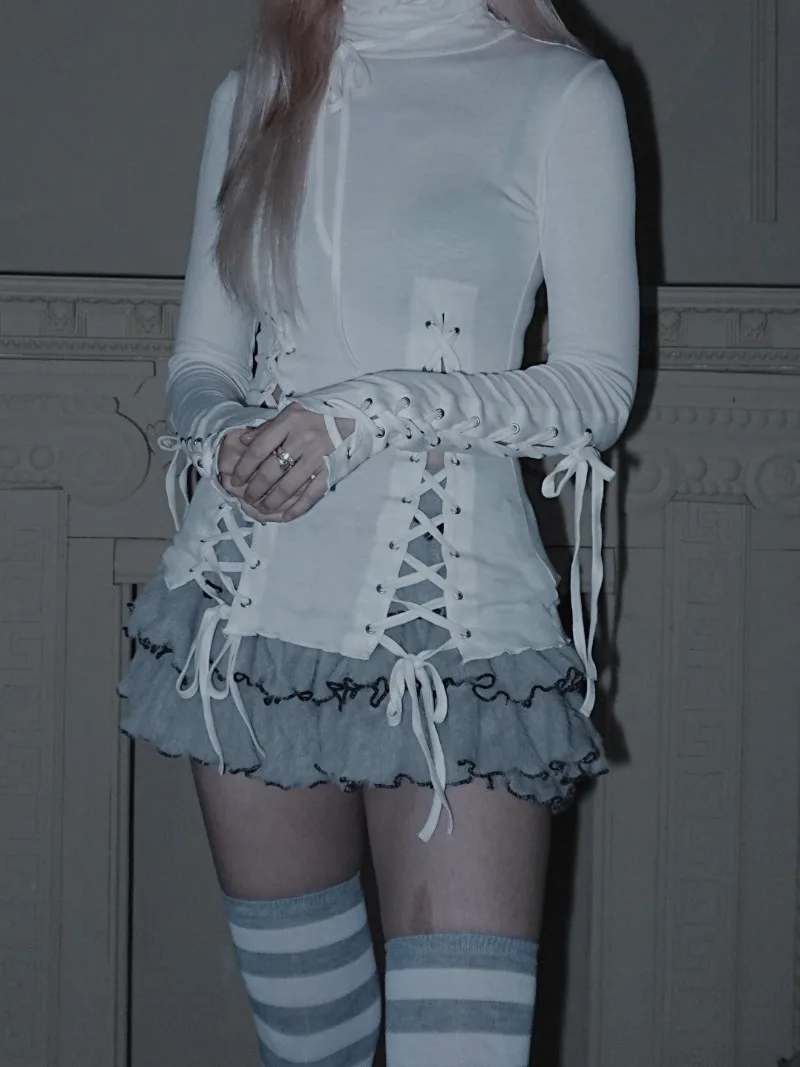 Czarno-biała, perforowana, sznurowana, dopasowana bluzka z wysokim dekoltem, koszulka bazowa, falbanki na brzegach, lekko prześwitująca, wysoce elastyczna dzianina.