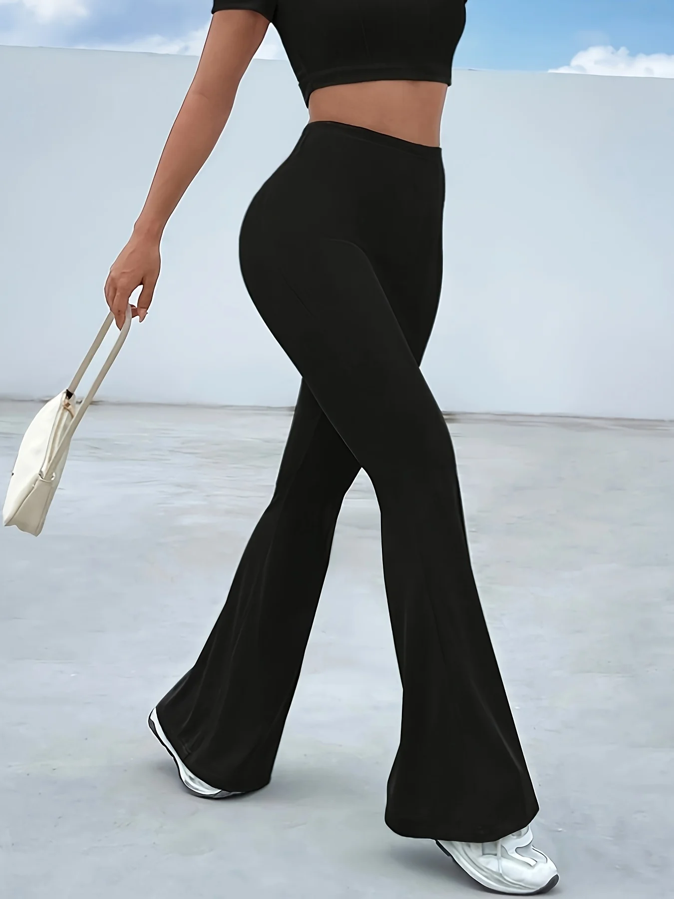 Czarne legginsy damskie na wiosnę, spodnie codzienne, lekko rozszerzane nogawki, elastyczny materiał z wysokim stanem dla komfortu.