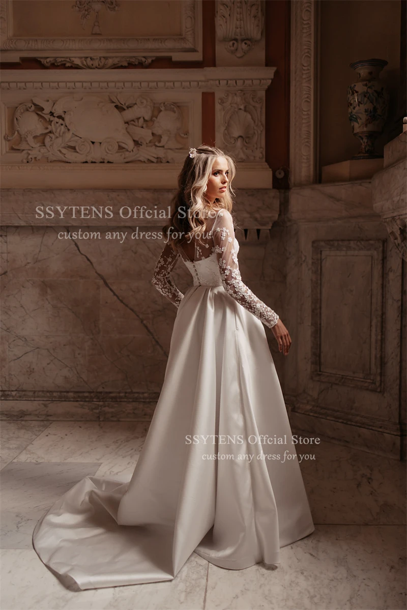 ชุดแต่งงานทรงเอไลน์สุดหรูจาก SSYTENS สีขาว ประดับด้วยลูกไม้ แขนยาวแบบซีทรู  ชุดเจ้าสาวแบบคอร์เซ็ทสั่งตัดได้ ปี 2026