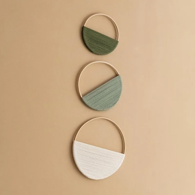 Macrame wall shelves displaying small potted plants