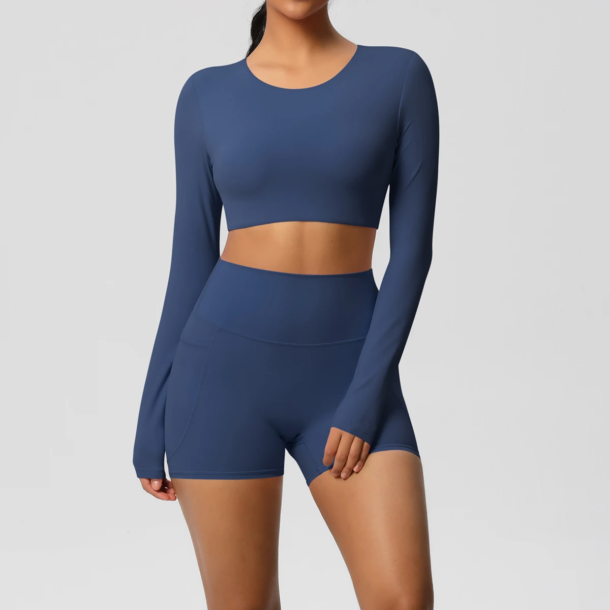 ชุดโยคะผู้หญิง ชุดออกกำลังกาย สีพื้น ทรงเข้ารูป แขนยาว แห้งเร็ว กางเกงขาสั้นฟิตเนสทรงพีชบัตต์เทิ้ล มีกระเป๋า