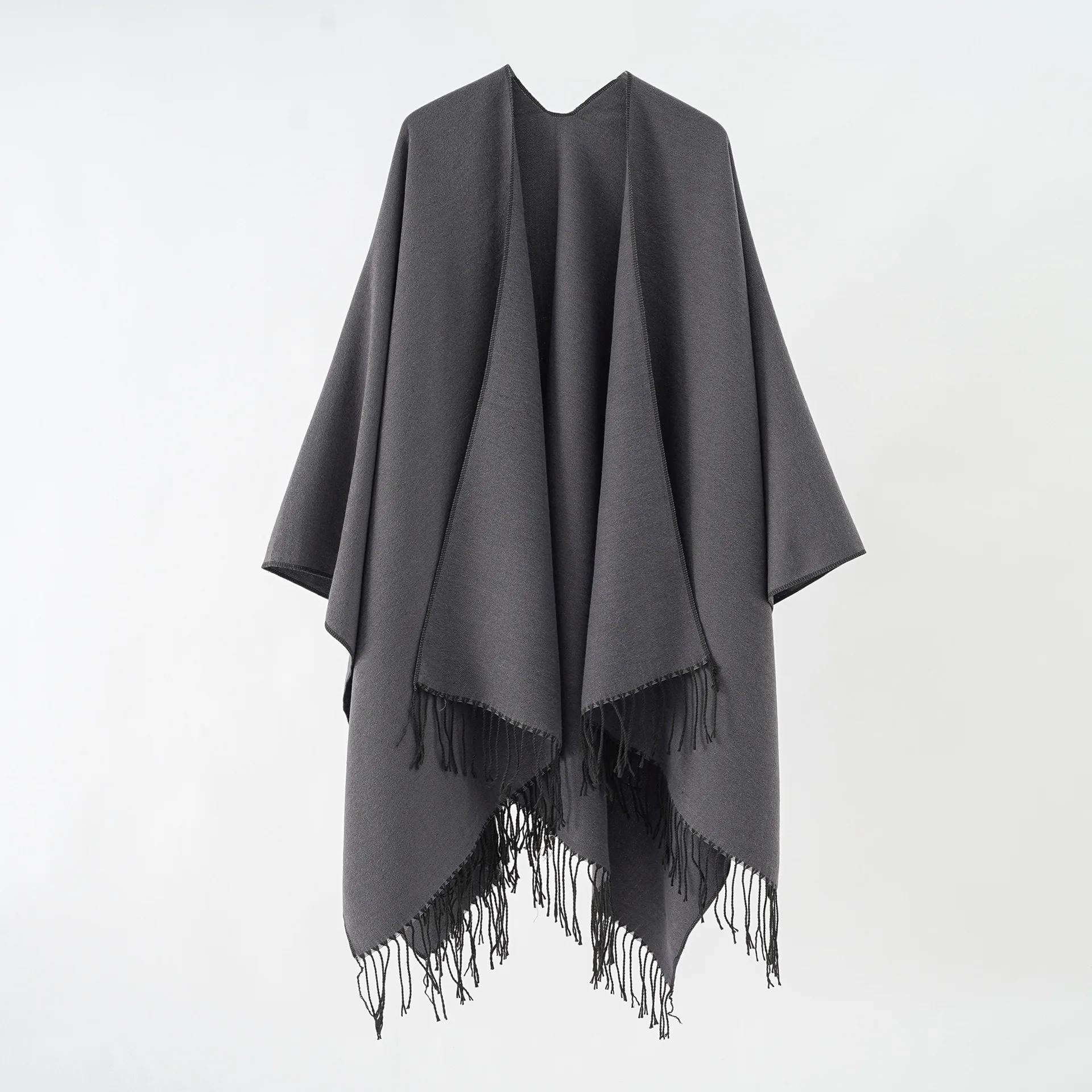 A woman's shawl a plain-colored, monochrome cape with a large split shawl and imitation cashmere tassels