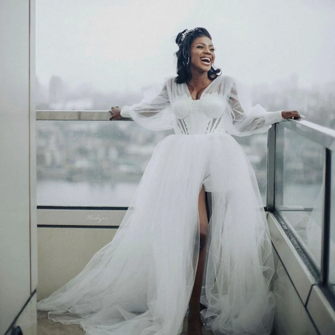 Suknia ślubna w kształcie litery A z dekoltem w serek, tiulowa, z długimi rękawami typu lampion, prześwitująca, z rozcięciem, idealna na przyjęcie weselne.