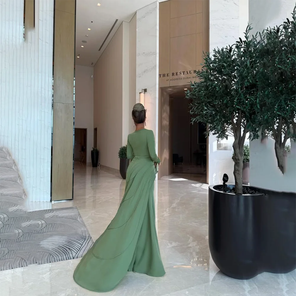 ชุดราตรีสีเขียวแบบสั่งตัด คอทรงโอ แขนยาว ทรงเมอร์เมด กระโปรงยาวทรงทรัมเป็ตจีบระบาย ชุดราตรีออกงานปี 2025