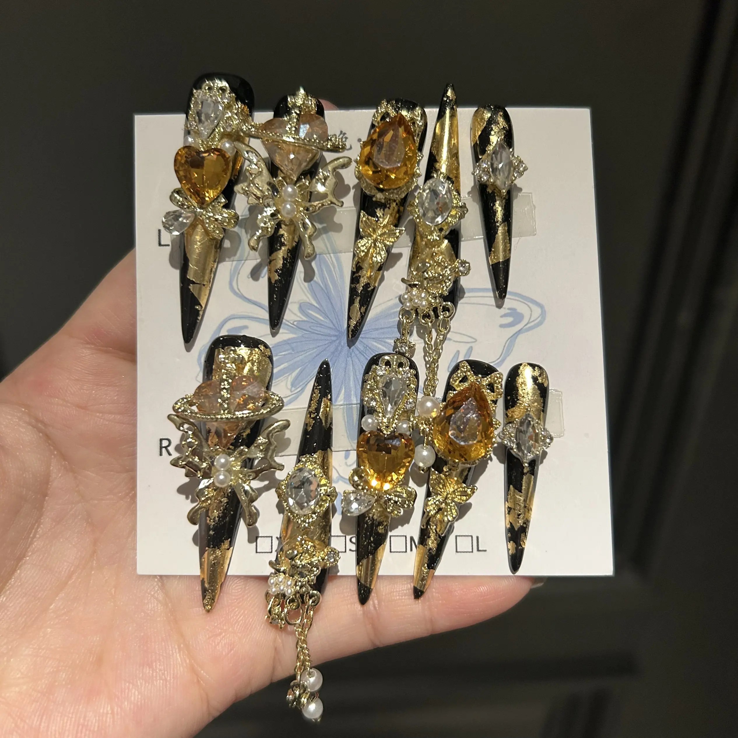 

Накладные ногти Black Gold Scepter Luxury Baroque Press On Nails, очень длинные, в форме стилетто, с черно-золотым градиентом, 3D-эффектом, кристаллами цвета шампань, металлическим кружевом и жемчугом.