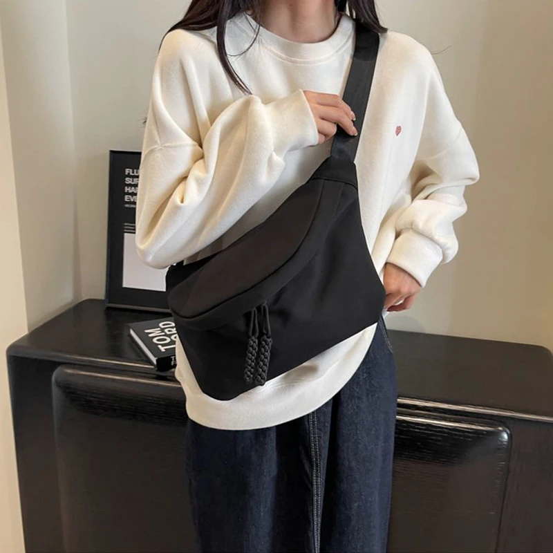 Quadratische Umhängetasche in neutraler Farbe für Damen und Herren, mit schlichtem Design, geeignet zum Tragen auf Reisen oder für den Arbeitsgebrauch.