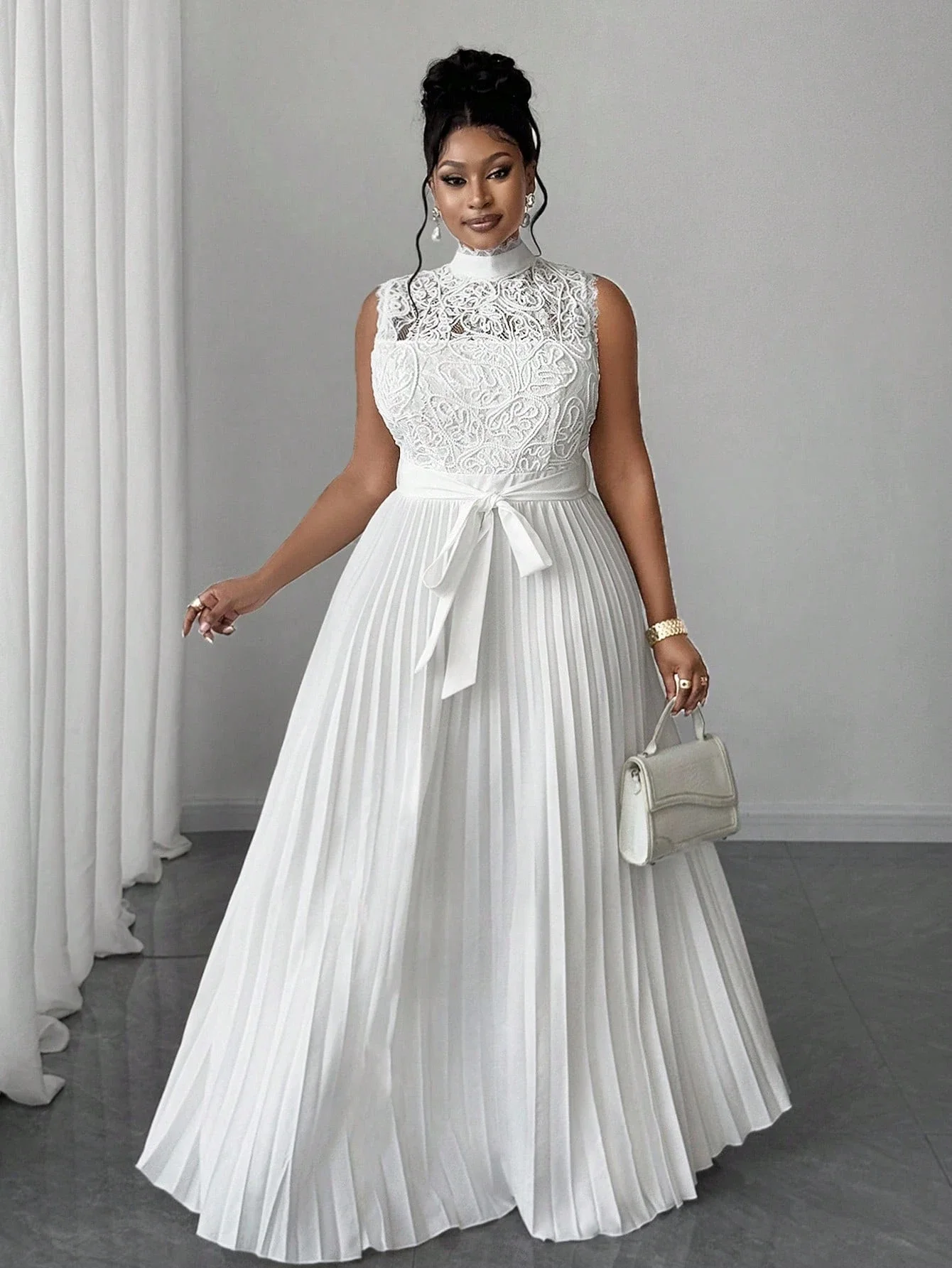 

Элегантное вечернее платье больших размеров с высоким воротником, без рукавов, с кружевным лифом, плиссированной юбкой в пол, завязкой на талии и молнией сзади.