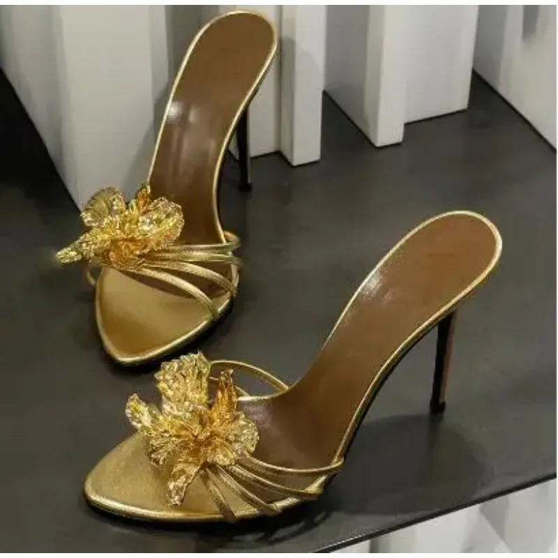 Damen Schwarze Goldene Echtleder-Sandalen mit Goldmetall-Blumenverzierung, Offene Zehenpartie, Flacher Slip-on Stiletto-Absatz