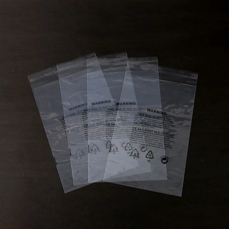 TETP 100Pcs Transparent Self Adhesive Bags With Warning Word For T-shirt Pants Bath Towel Packaging Display Home Storage Bag