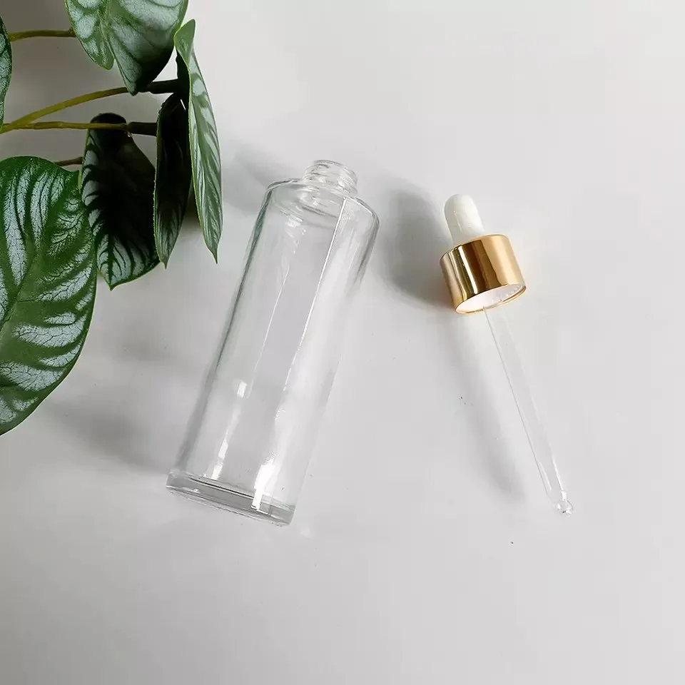 Wholesale 20-100ml Transparent Flat Shoulder Glass Essential Oil Serum Dropper Bottle With Gold Lid Skin Care Emulsion Container