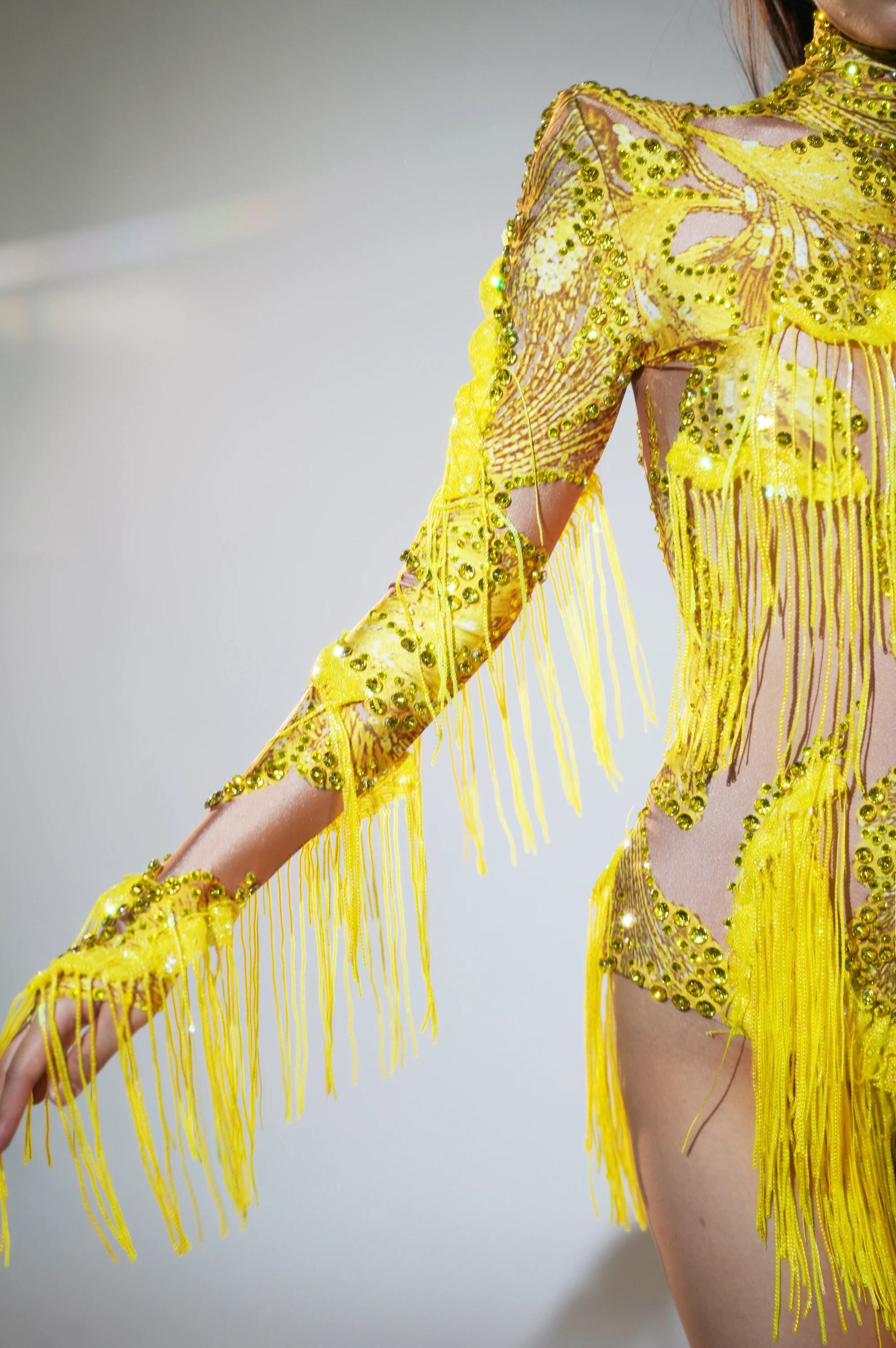 Damski kombinezon z jednym rękawem, frędzlami i wysokim wycięciem, idealny na występy taneczne latynoamerykańskie, modne stroje sceniczne dla grup i występów śpiewowych.