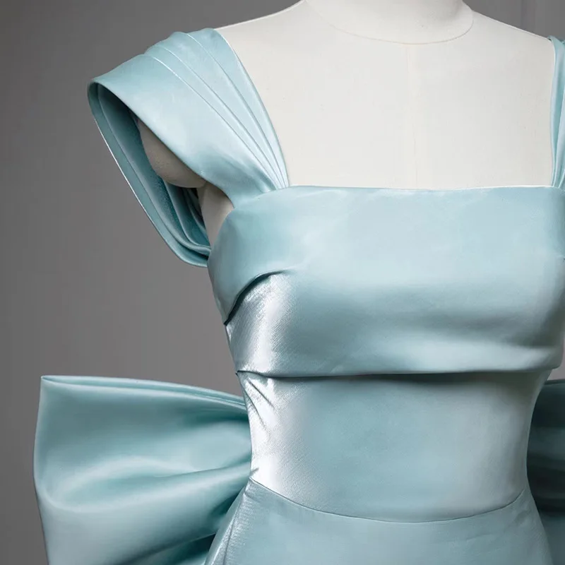 فستان سهرة نسائي من الساتان ذو ياقة مربعة بدون أكمام بتصميم نحيف للحفلات الراقصة والولائم بفيونكة كبيرة وذيل فيستدوس دي غالا