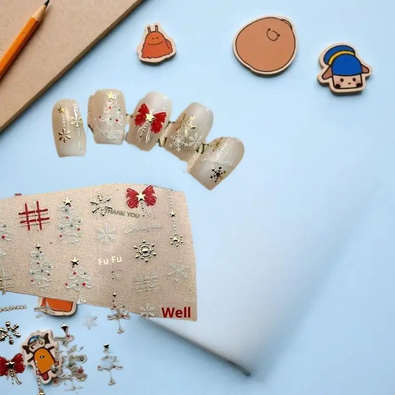 تصميم شجرة بيضاء ساحرة لعيد الميلاد مع ملصقات فنية للأظافر على شكل ندفة الثلج وأقواس حمراء تتميز بطباعة منقوشة