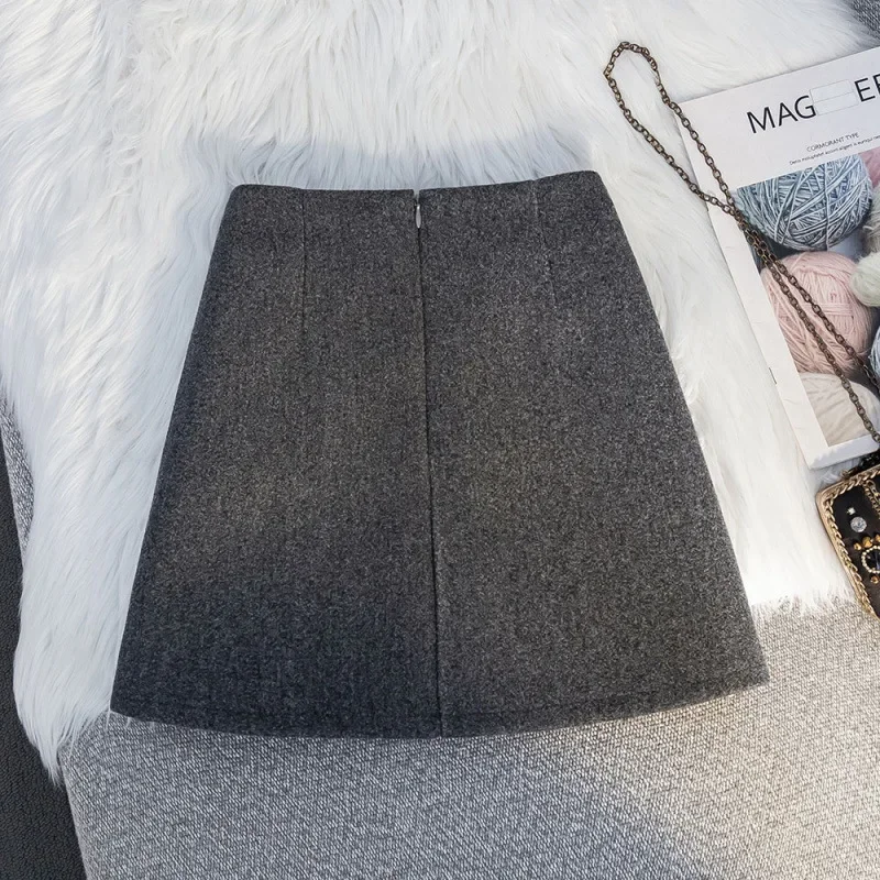 French high-grade gray woolen A-word skirt in autumn and winter, the new high-pocket hip irregular pleated skirt short skirt.