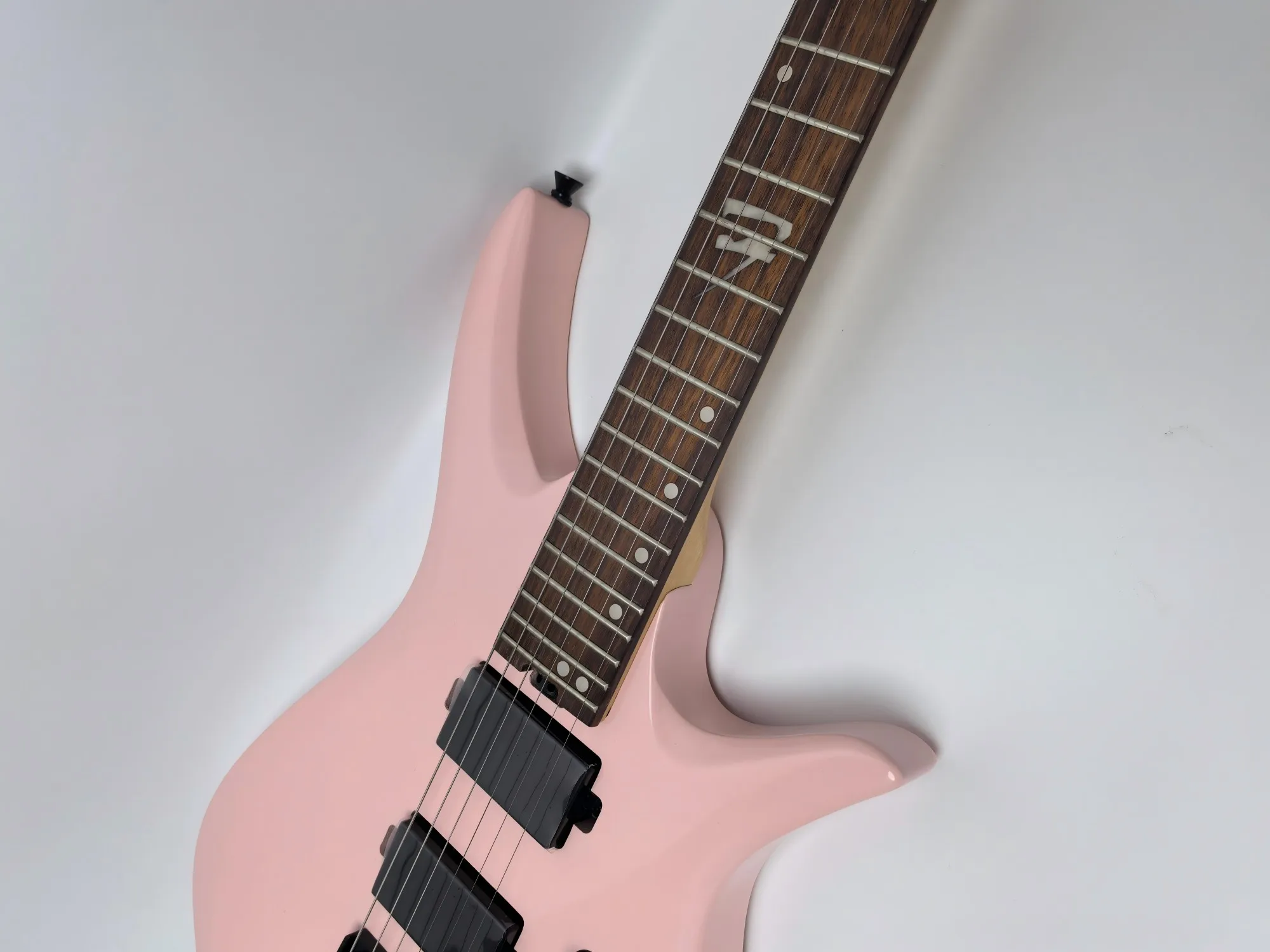 In stock. Can be shipped when placed. High quality pink headless 6 string electric guitar. Factory direct. Can be customized.