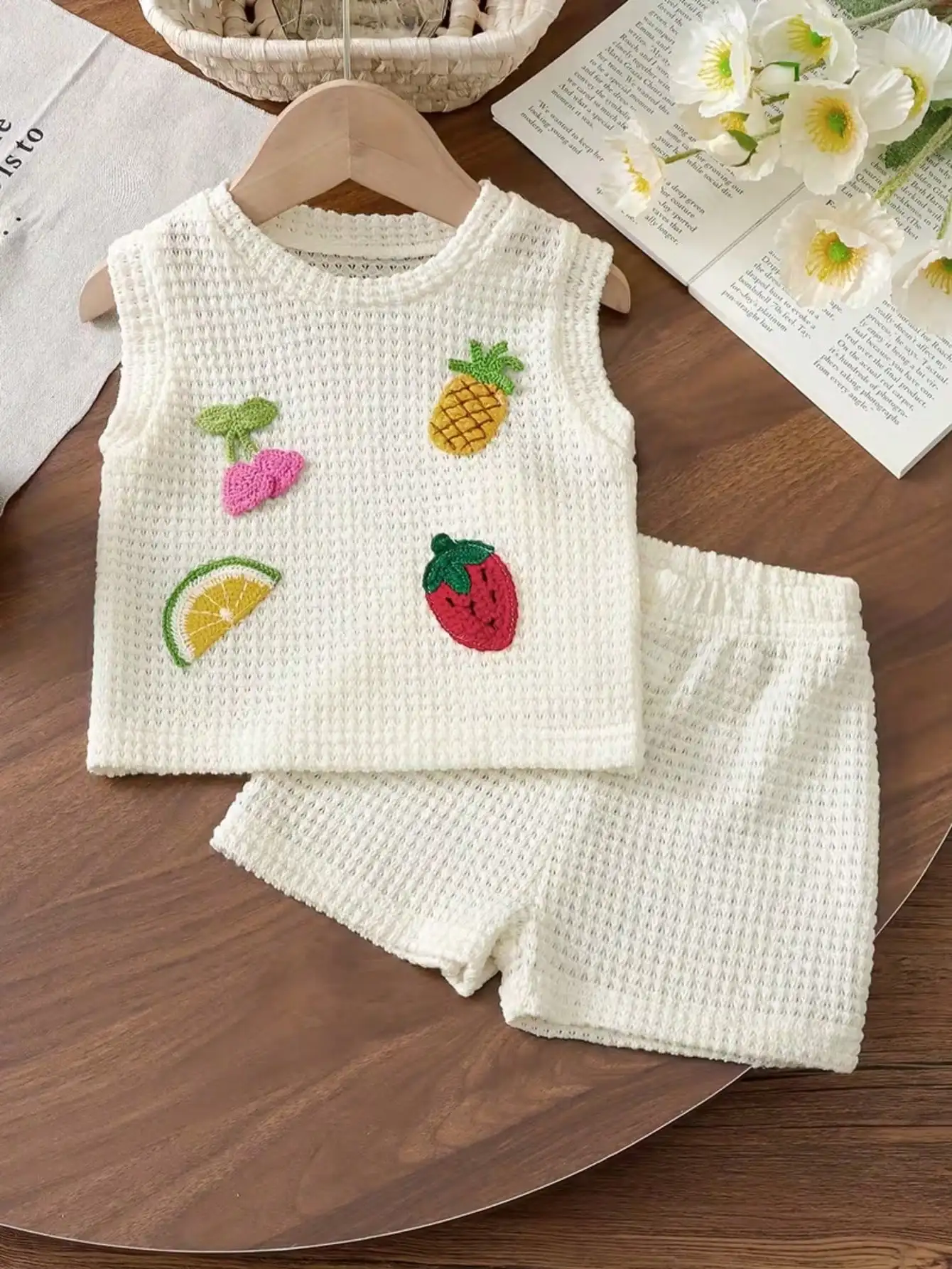 Kinder-Set mit Rundhals-Oberteil aus Strickstoff mit Fruchtmuster und ärmellosen Ärmeln sowie einfarbigen Shorts mit elastischem Bund. – Detail 4
