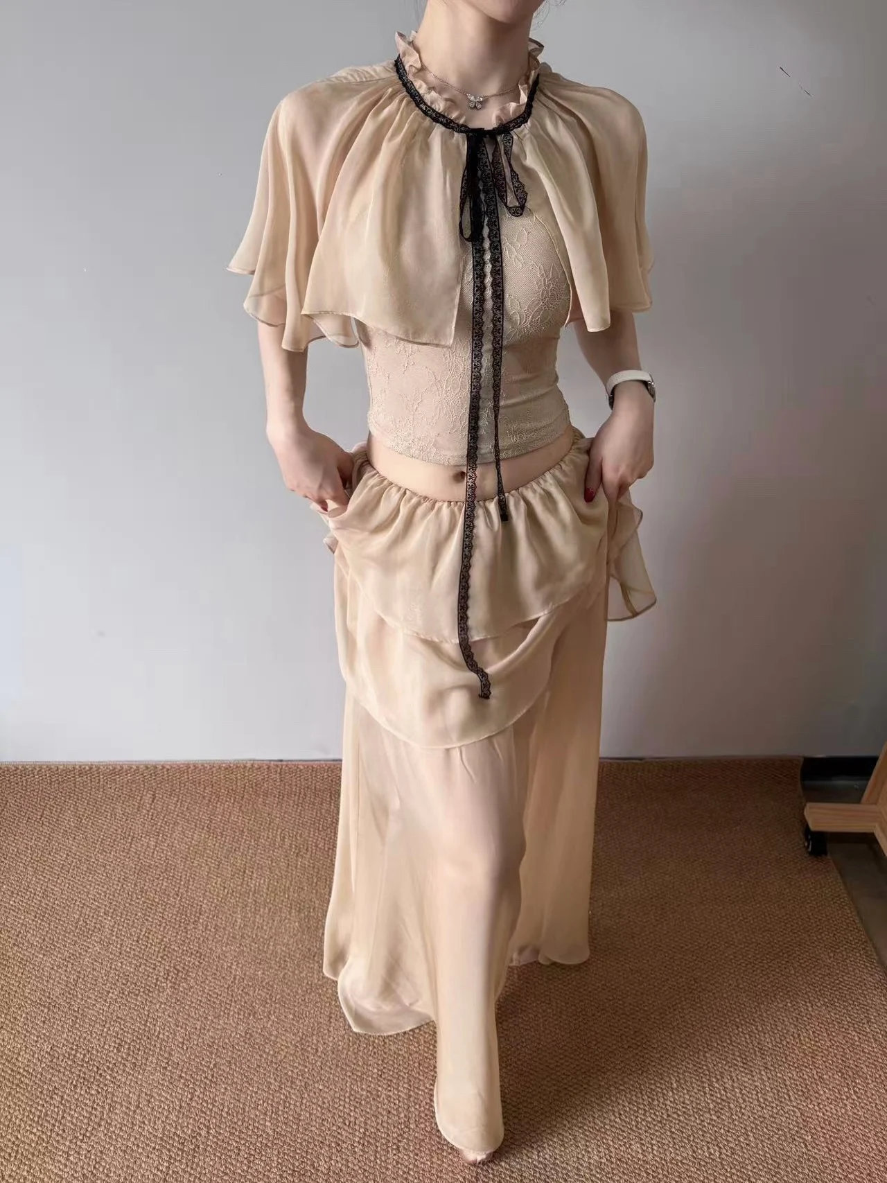 

Комплект Jqwention 2026SS: кружевная накидка на плечи, шифоновый топ с завязками и утягивающая юбка-полусолнце. Женская модная коллекция Весна.