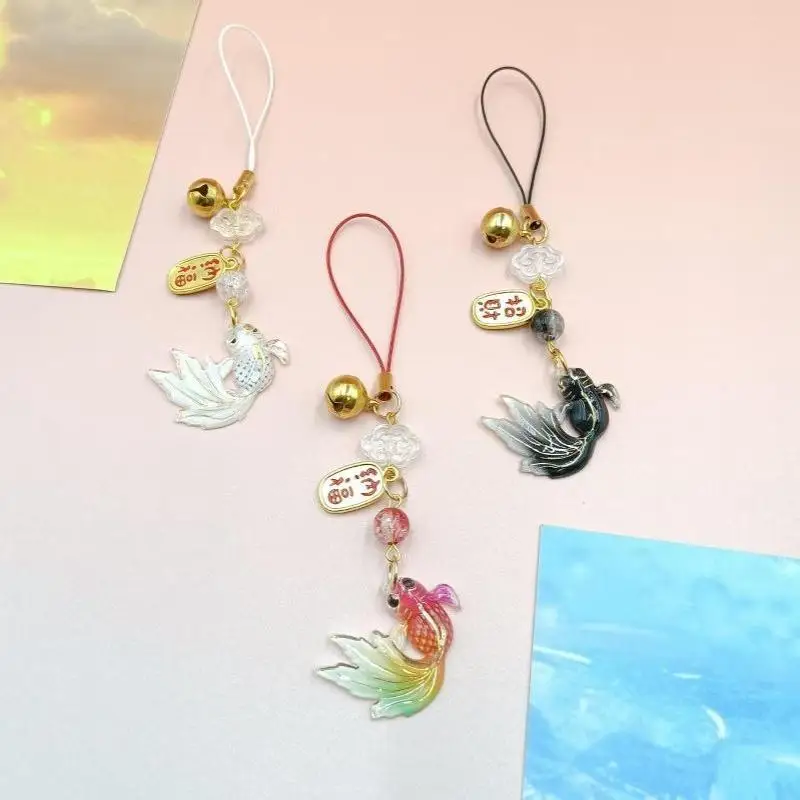 Buntes Handyband mit Farbverlauf und Goldfisch-Motiv, inklusive kleiner Glöckchen-Anhänger, ein schönes Geschenk für Taschen und Rucksäcke. – Detail 3