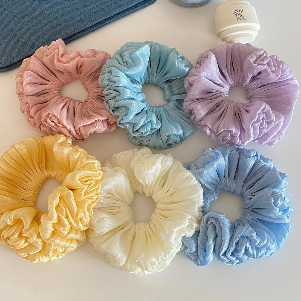 New bun scrunchie with pleats, a sophisticated and shimmering floral design, perfect for a fashionable and youthful look.