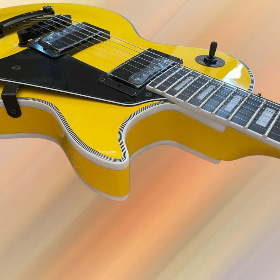 Yellow 6-string electric guitar with black hardware, rosewood fingerboard, and mahogany body view 2