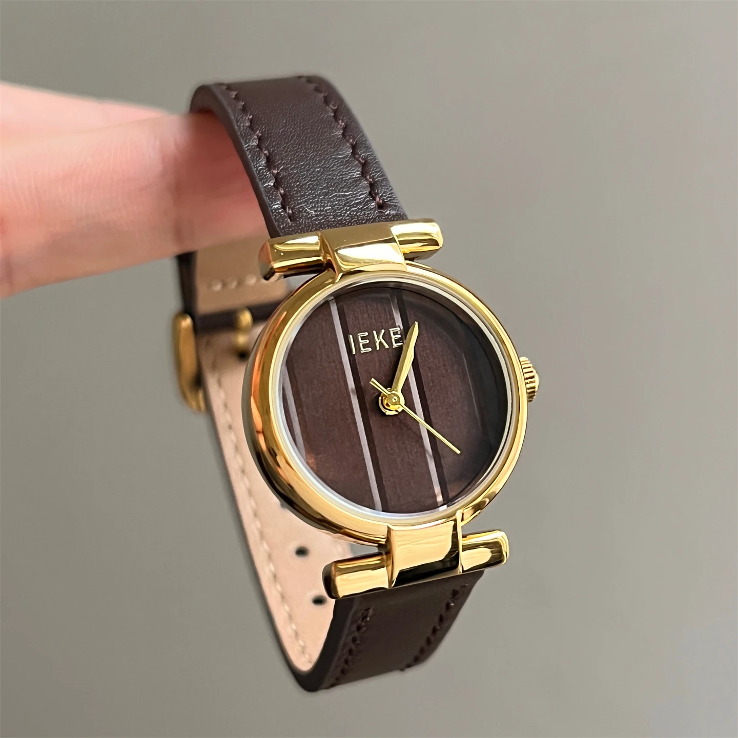 New dark brown round dial with vertical stripes, versatile for autumn and winter, sophisticated and stylish women's watch.