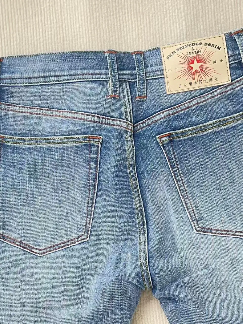 ฤดูร้อนน้ําหนักเบา 11oz สีแดง Selvedge DENIM Magnolia กางเกงยีนส์อินเทรนด์ผ้าฝ้าย 99% ล้างยืด Slim Tapered Fit กางเกงผู้ชาย 5KM