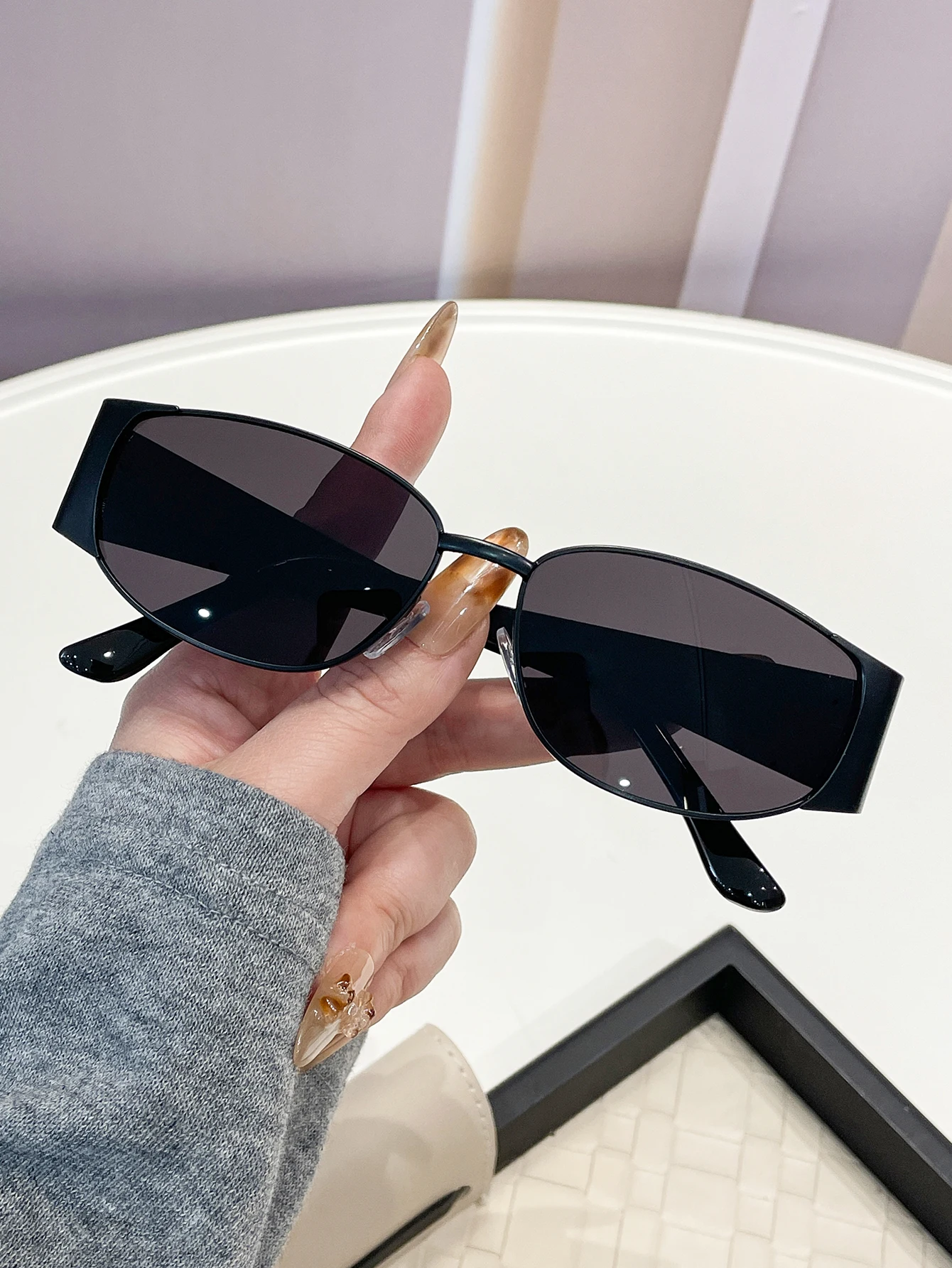 Elegante modische Brille mit ovalem Rahmen und dekorativen Bügelenden, geeignet für den täglichen Gebrauch und Straßenfotografie