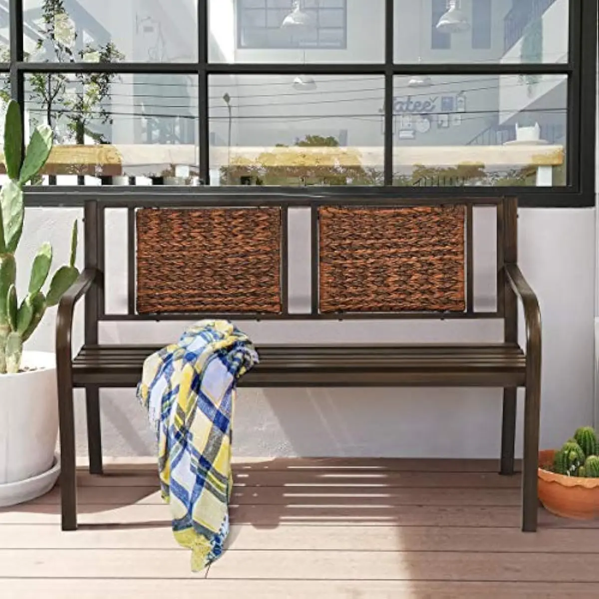 Outdoor patio bench with ergonomic sling backrest and curved armrests, brown powder-coated iron frame, PE rattan slats, 50.5 inc