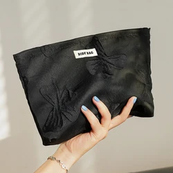 Borsa per il trucco da donna, fiocco nobile nero, rossetto di grande capacità, cuscino d'aria, tovagliolo sanitario, borsa portaoggetti, borsa da toilette portatile