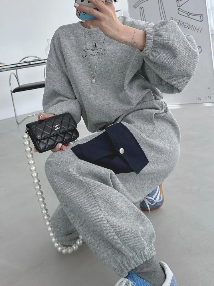 

Стильный спортивный женский костюм: свитшот свободного кроя с буквенным принтом и брюки с высокой талией. Осенне-зимний повседневный комплект из двух предметов.