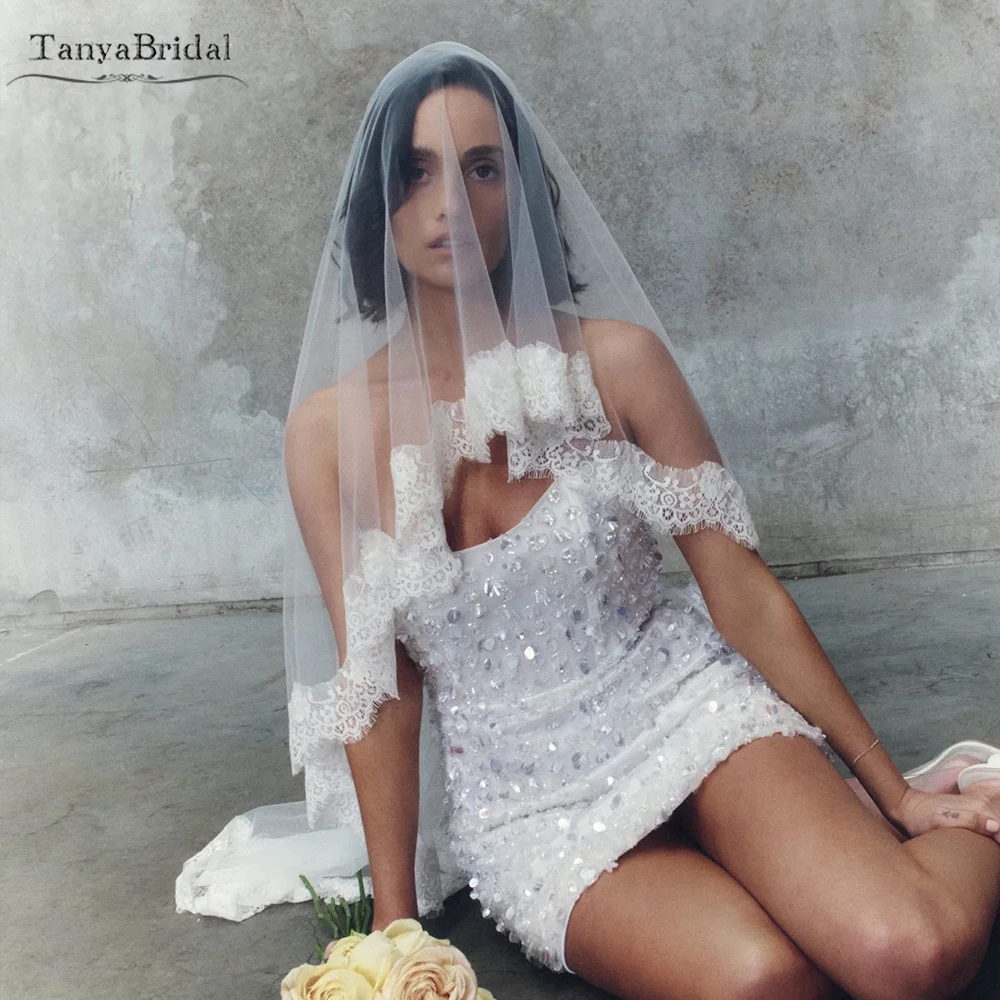 

Элегантная свадебная фата из тюля, деликатно украшенная кружевной отделкой ручной работы DV075