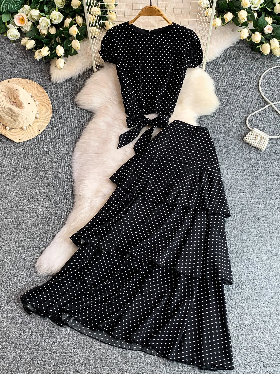 

Модный летний комплект из двух предметов: укороченный топ в горошек с рукавами-фонариками и плиссированная юбка с высокой талией на пояс. Идеально для повседневного стиля.