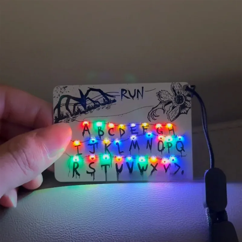 Tarjeta de mercancía de película, llavero con colgante de luz, 26 letras, bolsa ligera, amuleto de coche, regalos de Festival de mercancía de Anime