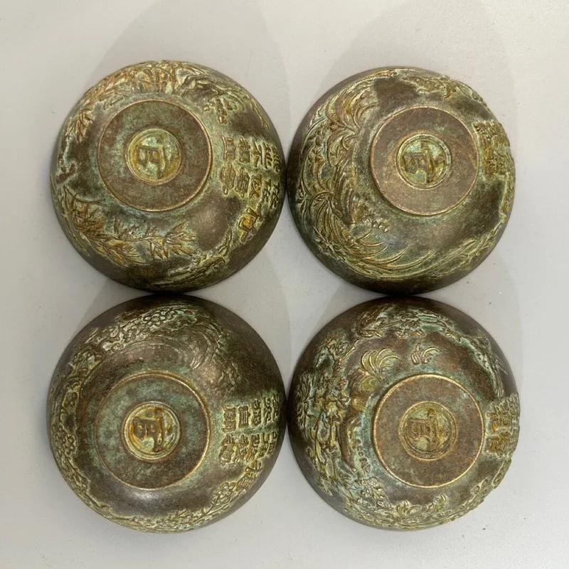 A set of copper tea bowls teacups featuring plum, orchid, chrysanthemum, and bamboo designs, a collection of artware