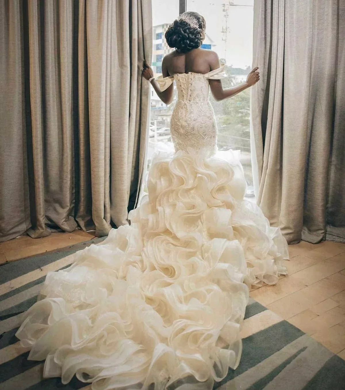 Suknia ślubna syrena z afrykańskimi, błyszczącymi perłami, z odkrytymi ramionami i kaskadowymi falbanami.