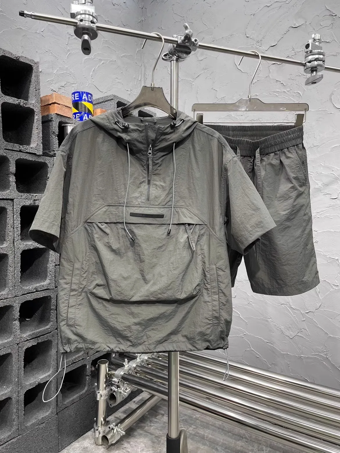 

Комплект мужской летней рабочей одежды из Гуанчжоу: тонкая футболка с капюшоном и быстросохнущие шорты с карманами и эластичным поясом (13 рядов)