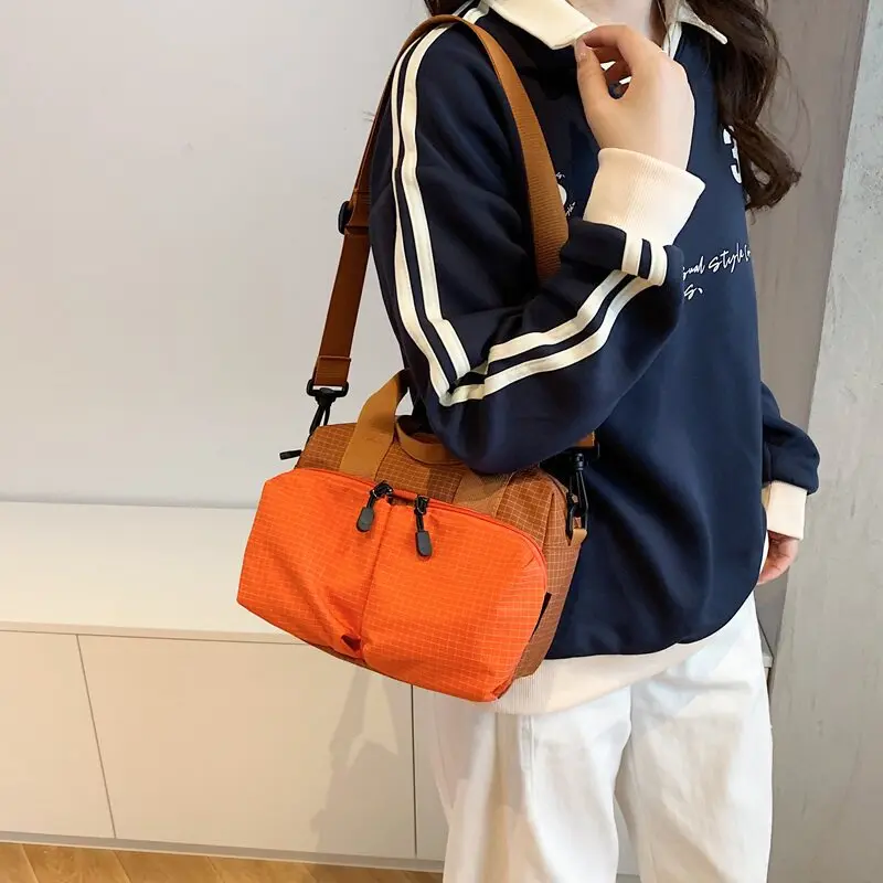 Large-capacity, lightweight crossbody bag for women, made of nylon fabric, featuring a plaid pattern, multiple pockets, and suit