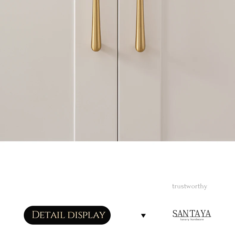 Vertical brass handles on a white cupboard
