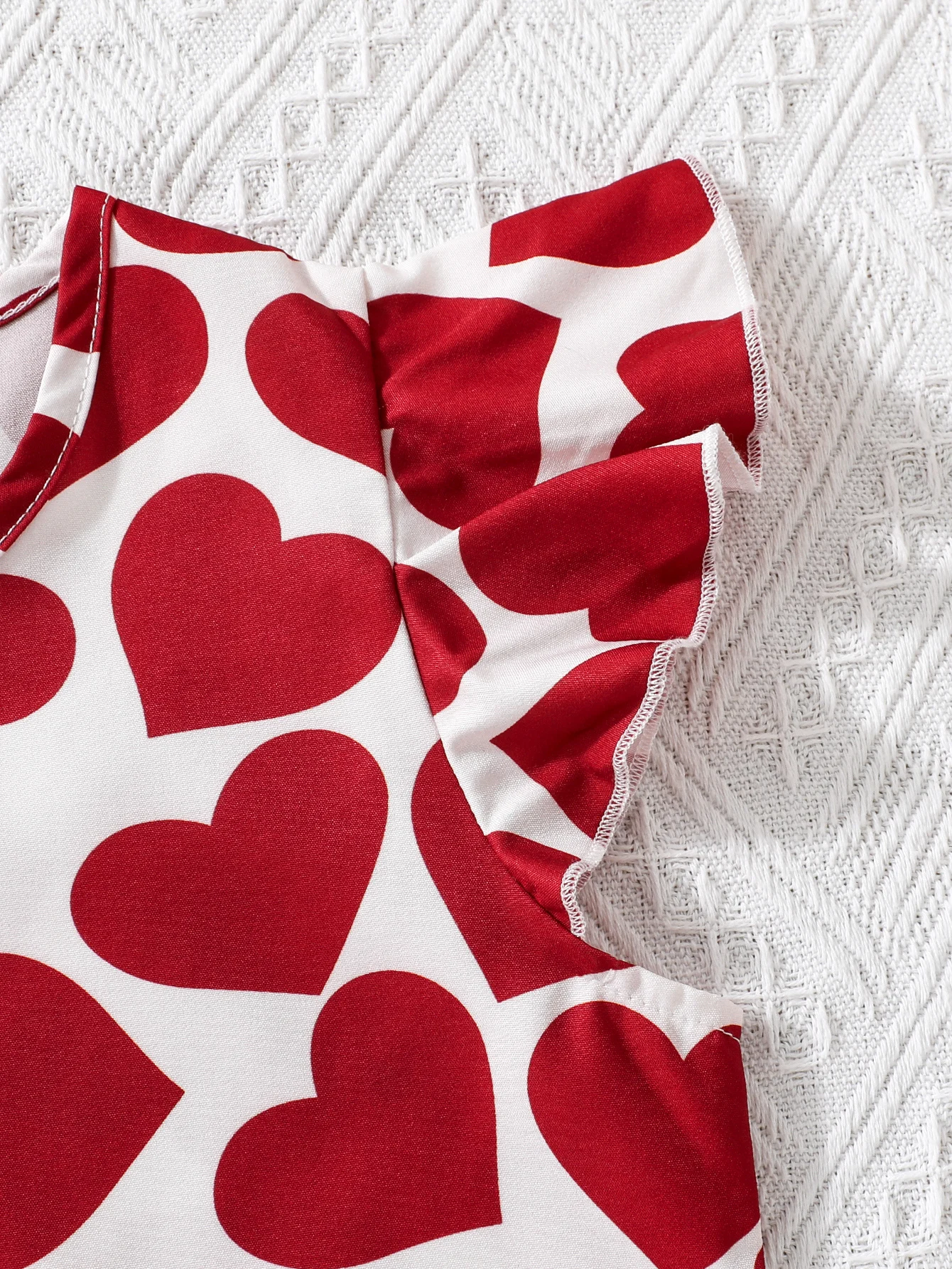 Abito da ragazza alla moda con stampa a cuore: abbinamento di colori rosso e bianco e design sul petto sul davanti