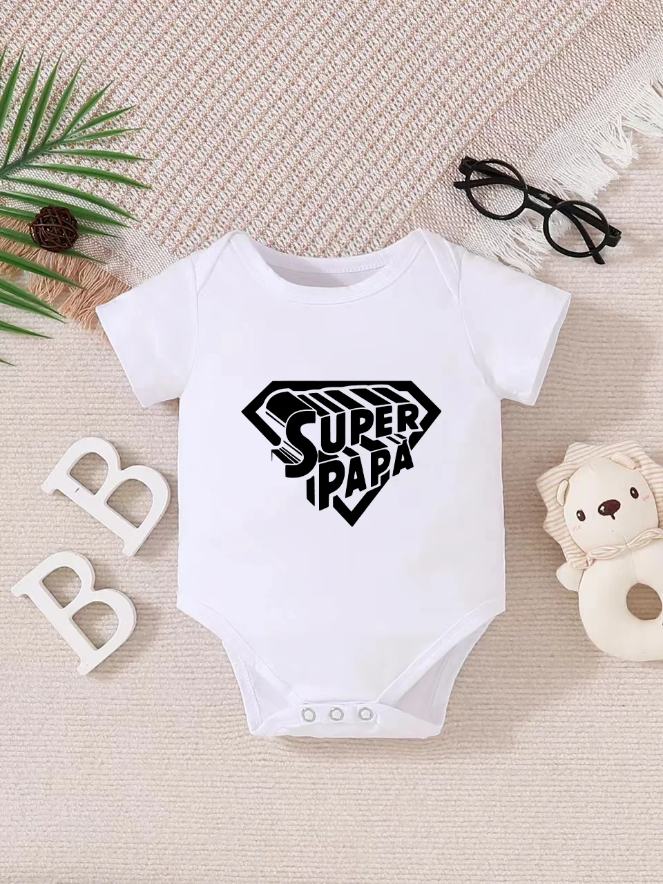 Playful letter-printed baby short-sleeve triangle bodysuit. Button closure for easy dressing, machine washable