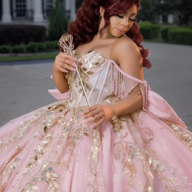 

Розовое платье для церемонии Quinceanera с открытыми плечами, золотистыми кристаллами, цветочными аппликациями, кружевными оборками, длинным шлейфом и бантом, платья для церемонии Quinceanera. ﻿ Настройте на свой вкус