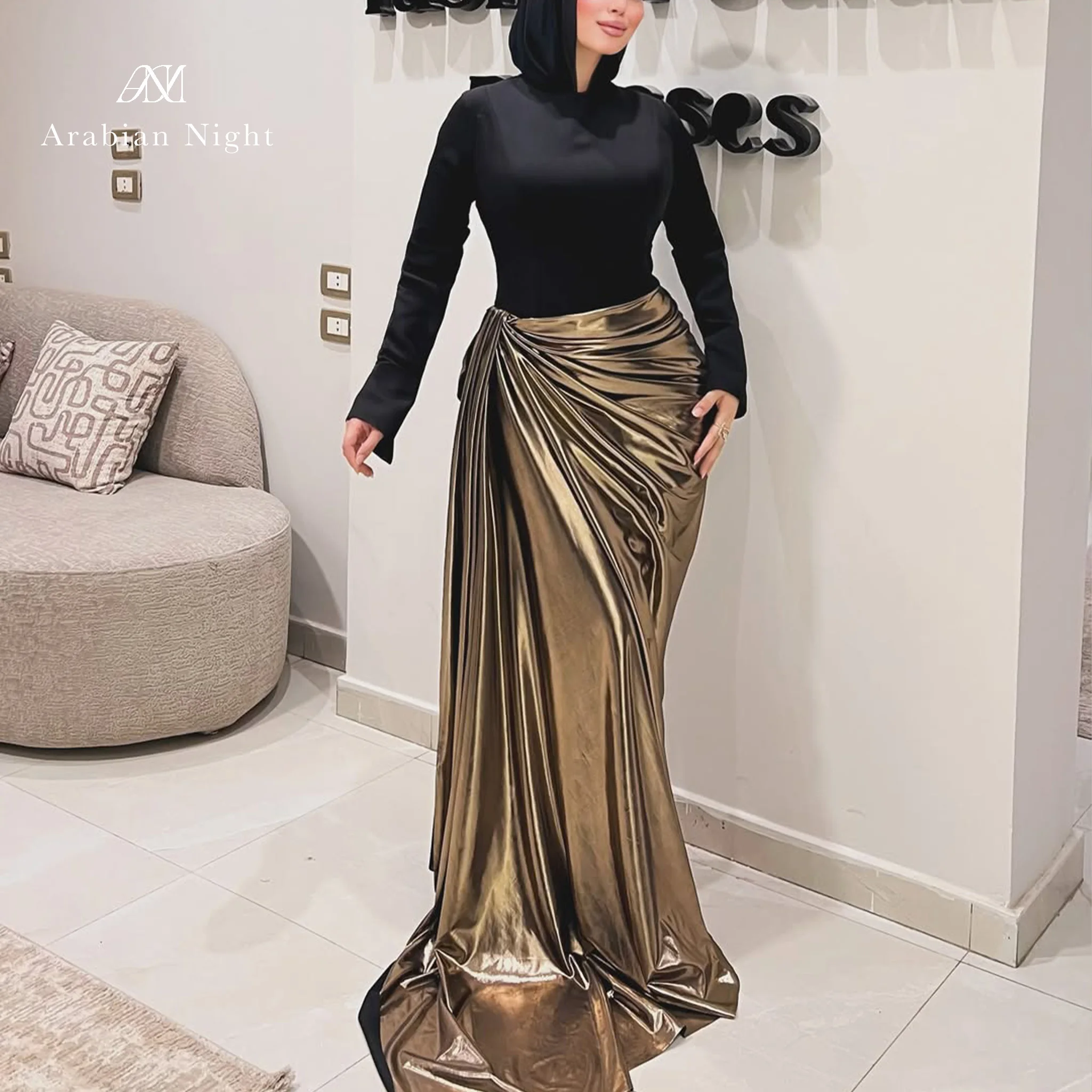 Black long-sleeved hooded formal gown with a draped bodice and a floor-length gold fishtail skirt