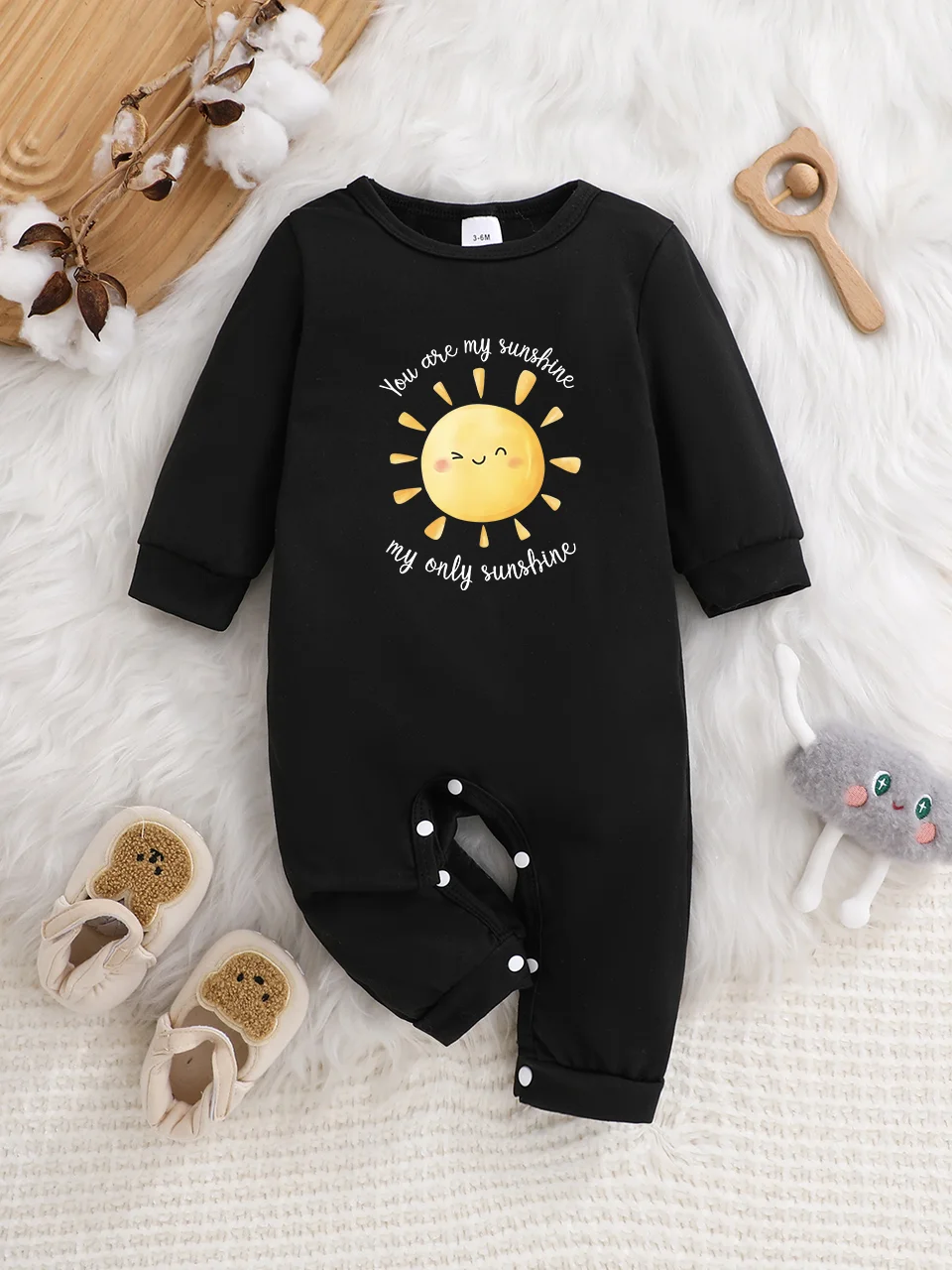 Ein langärmliger Baby-Strampler mit interessanten Buchstaben-Prints. Es verfügt über ein Knopfverschluss-Design für einfaches An- und Ausziehen.