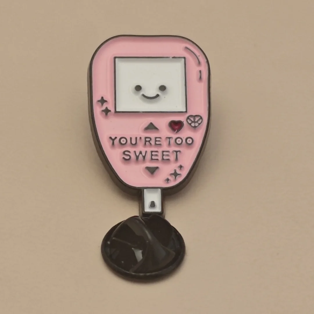 A unique and cute metal brooch in the style of a handheld gaming console, suitable for women to wear.